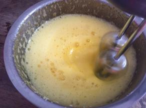 边倒入蛋黄糊里，边用电动打蛋器打发