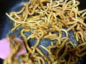 倒入炸好的面条，撒上葡萄干，用刮棒快速的搅拌均匀