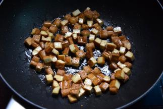 锅中倒入花生油，下豆腐丁半煎半炸至金黄盛出待用