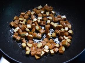 锅中倒入花生油，下豆腐丁半煎半炸至金黄盛出待用