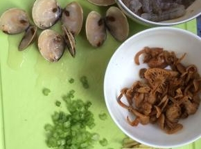 将文蛤对半切开（我的文蛤是放冰箱冷冻的所以需要切开，如果是新鲜的文蛤可忽略这一步），芹菜切小丁，姜切丝，鸡针菇泡开，备用