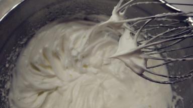 往蛋白中分3次加入糖粉A，打至干性发泡。（首先，用打蛋器低速将蛋白搅打至起鱼眼泡，加入1/3的糖粉。接着，继续用电动打蛋器高速搅打，至蛋白体积膨胀1倍，再加入1/3的糖粉。然后，继续用电动打蛋器中速搅打，稍微出现纹路，加入剩余的1/3的糖粉。最后低速搅打，直至明显感到阻力，提起打蛋器时尖端是短而小的尖峰即可。）