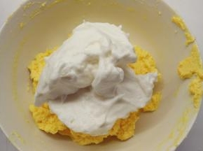 取1/2的蛋白霜加入到黄油糊中，用橡皮刮刀用翻拌的手法拌匀。