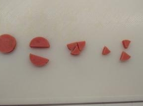 蛋糕烘烤期间我们来做装饰的材料。取一根火腿肠，切成2mm左右的薄片，对半切开之后再切成3个三角形，做小鸡的嘴。