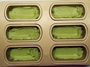 将抹茶面糊平均地挤入到模具中，用刮刀稍微抹平。