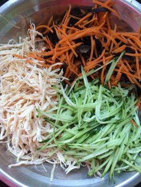 将黄瓜丝，胡萝卜丝，木耳，鸡丝一起放入大一点的容器中