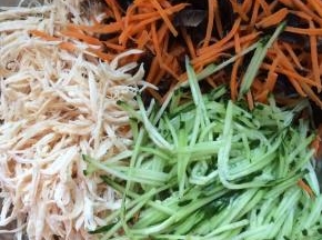 将黄瓜丝，胡萝卜丝，木耳，鸡丝一起放入大一点的容器中