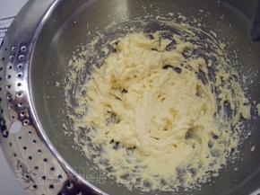 蛋糕烘烤期间我们来做装饰用的黑芝麻奶酪霜。室温软化好的奶油奶酪和黄油加入糖粉，开动电动打蛋器，一直搅打到奶酪霜非常蓬松，纹路清晰可以裱花的状态。