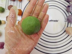 一手大拇指按住馅料，另一手虎口往上推饼皮，使它紧贴着馅料并慢慢地往上爬，最后收口，并将其滚圆。