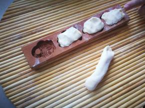 将发酵好的面团取出，排气，滚成长条状。揪成小剂子放入模具中。