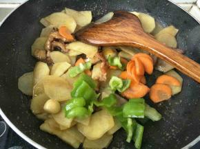 加入土豆，青椒，胡萝卜片翻炒两分钟左右