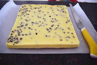 出炉后放置1分钟稍微冷却然后倒扣到新的吸油纸上，掀开底部的硅胶垫。用刀在蛋糕体上间隔2厘米，浅浅划上一刀，然后紧紧卷起，定型30分钟。