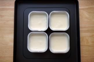 将煮好的奶倒入准备好的4个锡纸小碗里。热奶慢慢冷却，冷却的过程中，表面会结出一层奶皮。