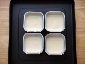 将煮好的奶倒入准备好的4个锡纸小碗里。热奶慢慢冷却，冷却的过程中，表面会结出一层奶皮。