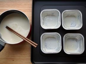 结好奶皮以后，把碗里的奶倒回奶锅（用筷子挡住奶皮再倒），将奶皮留在碗里。（倒的时候，不要把奶全都倒完，留一点点在碗底。这样奶皮不会粘在碗底而是能浮起来。）