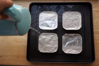 分别封上锡纸，并且往烤盘里注入沸水，液面最好可以浸泡到碗里的奶面位置。