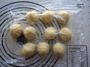 将发酵好的面团排气，然后分成10等份。揉圆，盖上保鲜膜，醒发15分钟左右。