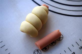 将长面团紧绕火腿肠，绕完后切去多余的火腿肠。