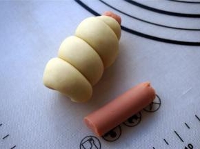 将长面团紧绕火腿肠，绕完后切去多余的火腿肠。