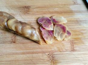 把腊肠洗净后，放入水中煮个十分钟，取出来，切成薄片。