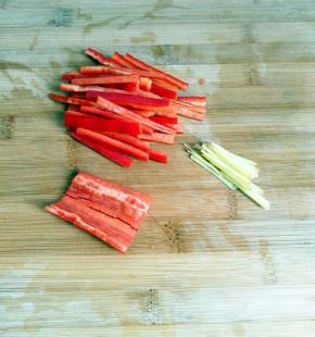 在把红椒，姜，还有蒜蒜苔切一下。