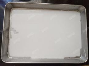 将肠粉盘左右晃动一下，让粉浆均匀的铺在盘子上