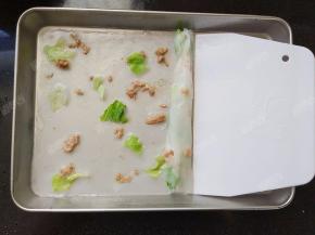 刮板从盘子一侧刮并卷起包住材料，一个肠粉就做好了