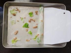 刮板从盘子一侧刮并卷起包住材料，一个肠粉就做好了