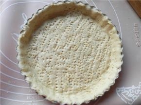 将圆片放入披萨盘内（学厨披萨盘不用刷油），用手指把当中的面饼往四壁按一按，用叉子在面饼上戳一些小孔。