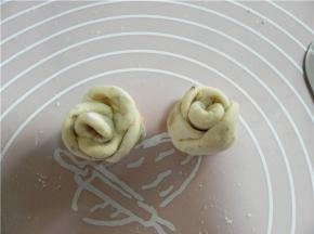 从下端由上卷起。用刀从中间切开，做好2朵玫瑰花。预热烤箱200度。
