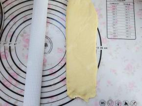 将松弛后的面团光滑面朝上，擀成长条形状