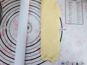 将松弛后的面团光滑面朝上，擀成长条形状