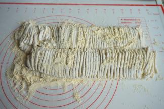 刀切成细条，放一旁，先不要抖散，煮之前再将上面的棒子面抖落下来