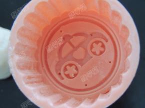 月饼模中撒一些熟糯米粉，将多余糯米粉抖干净