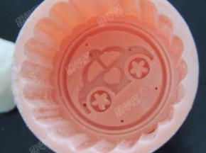 月饼模中撒一些熟糯米粉，将多余糯米粉抖干净