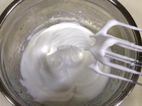 分三次加入细砂糖搅打至蛋白呈干性状态，提起打蛋头有挺立的尖角。