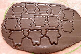 用熊猫饼干模具的身体部分在可可面团上压出熊猫的身体；