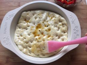 排气排好的面团放入模具中，用手戳一些凹点，刷一层橄榄油，这里的橄榄油我直接用的浸泡小番茄碗里的；