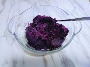 蒸熟的紫薯用勺子碾成紫薯泥，且无颗粒状。