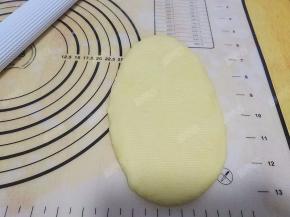 取一份面团压扁，用擀面杖擀开成长条形