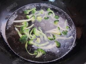 锅中倒入热水，加两勺盐，少量油，将西兰花倒入锅中焯水，变熟后捞出