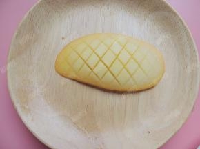 芒果切下一块来，在果肉上用刀划十字斜线，不要切断果皮