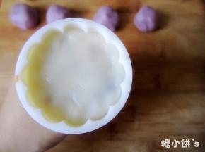 再取一个步骤8包好的月饼坯压入步骤9压过紫色面团的模具中，将底部压平
