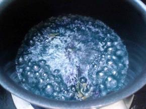 在原奶锅热水中加入4朵蝶豆花，开大火煮沸