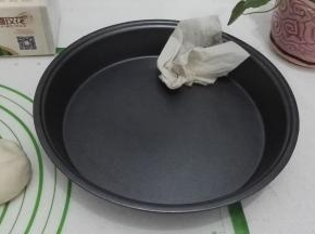 披萨盘洗净用厨房抽纸擦干，用手抹一层油防粘。