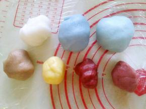 取适量白冰皮面团，依次加入红曲粉、南瓜粉、可可粉，彻底揉匀。
小贴士:喜欢绿色，可以加入适量抹茶粉，紫色可以用紫薯粉调色，黑色用深色可可粉或者竹炭粉调色。