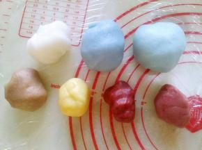 取适量白冰皮面团，依次加入红曲粉、南瓜粉、可可粉，彻底揉匀。
小贴士:喜欢绿色，可以加入适量抹茶粉，紫色可以用紫薯粉调色，黑色用深色可可粉或者竹炭粉调色。