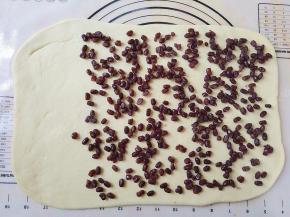 将蜜豆平铺在饼上，留三分之一不要铺