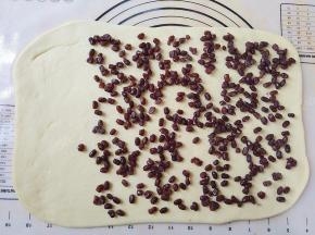 将蜜豆平铺在饼上，留三分之一不要铺