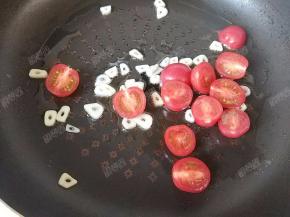放入小番茄，略微煸炒至番茄皮起皱